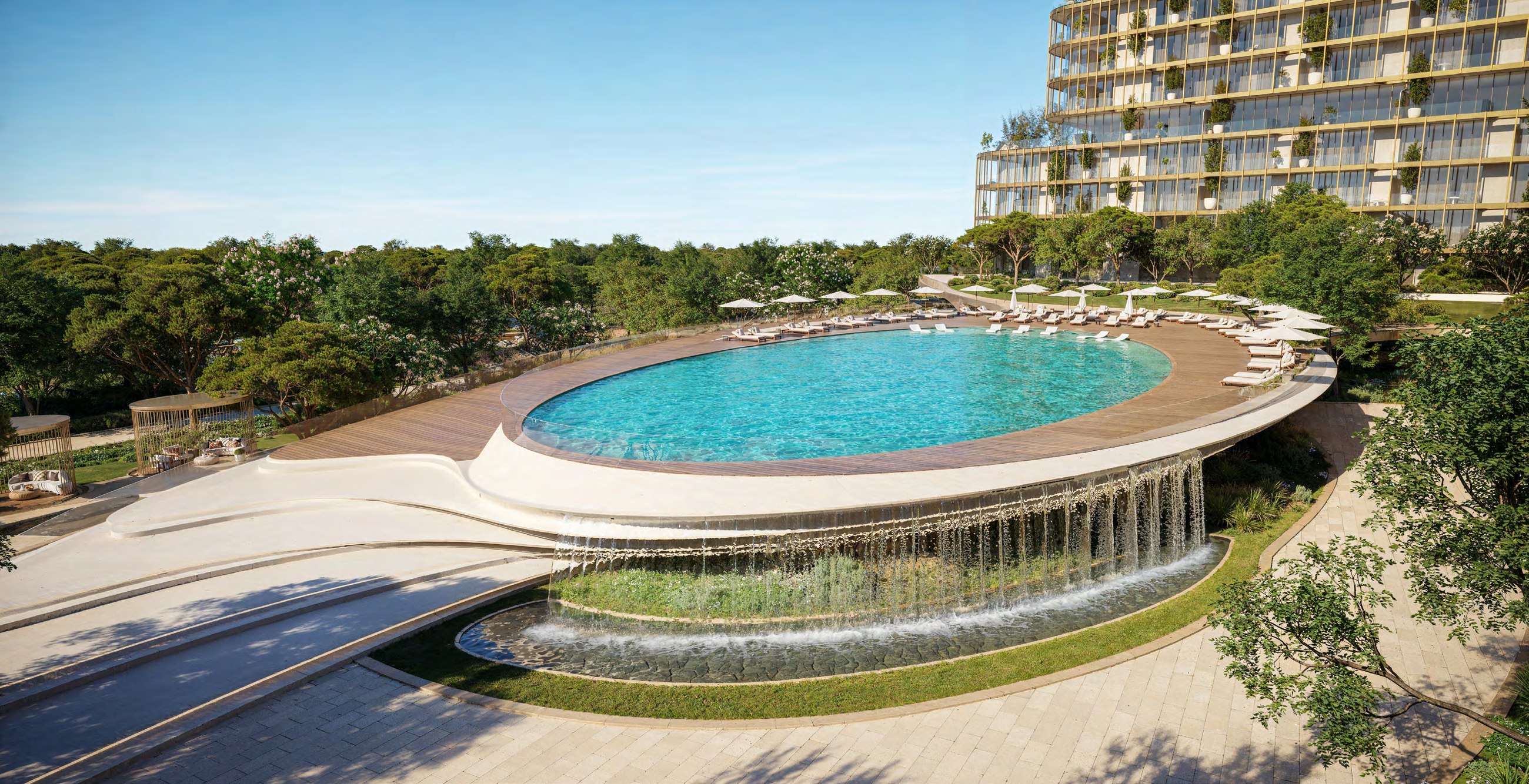 Elevated circular pool deck with cascading water edge and landscaped surroundings.