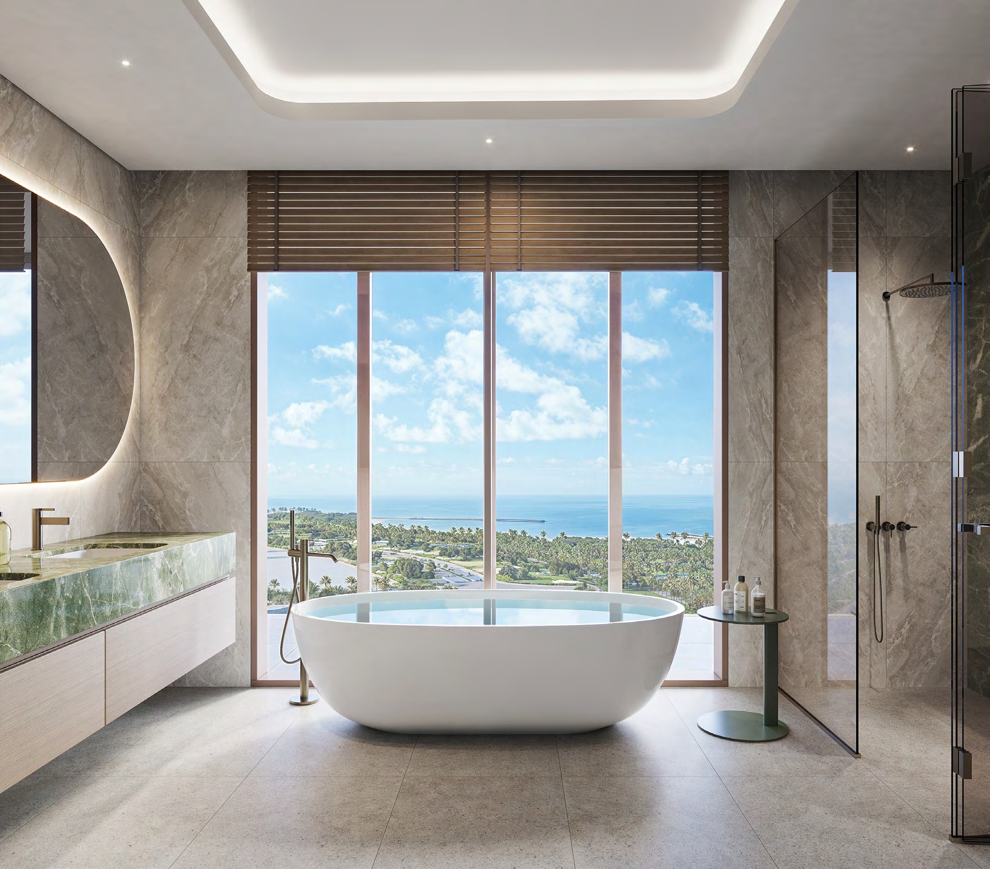 Stone bathroom with freestanding tub and sea view through full-height glazing.