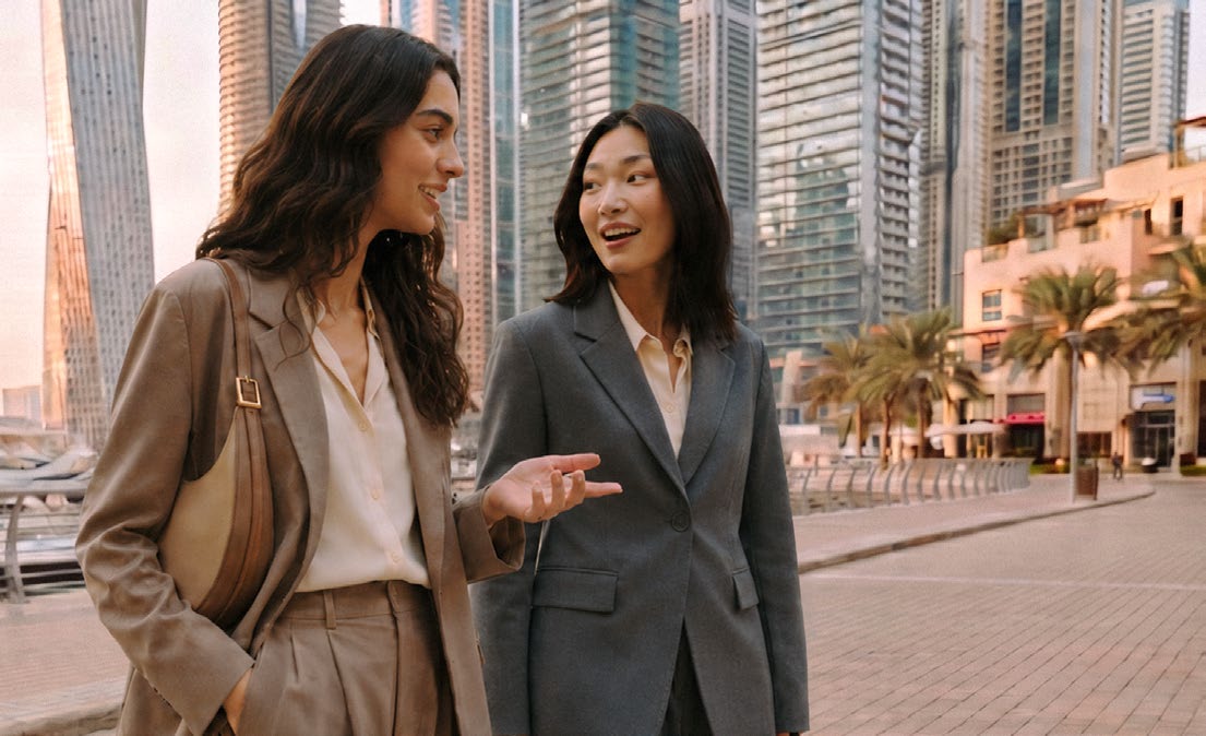 Two professionals walking through a modern Dubai urban district.